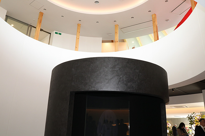 フロア中央は2階まで吹き抜けになっており、等身大サイズの「バーチャルLei」が設置されている。現在は事前入力したワードを手動操作で発話させているが、将来的にはカメラなどを設置して来場者を検知。ユピ坊のように応対を行なうようにするとのこと