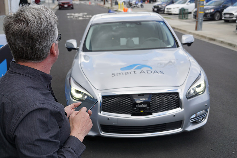 スマホを操作するオーナーの前にクルマがやってくる