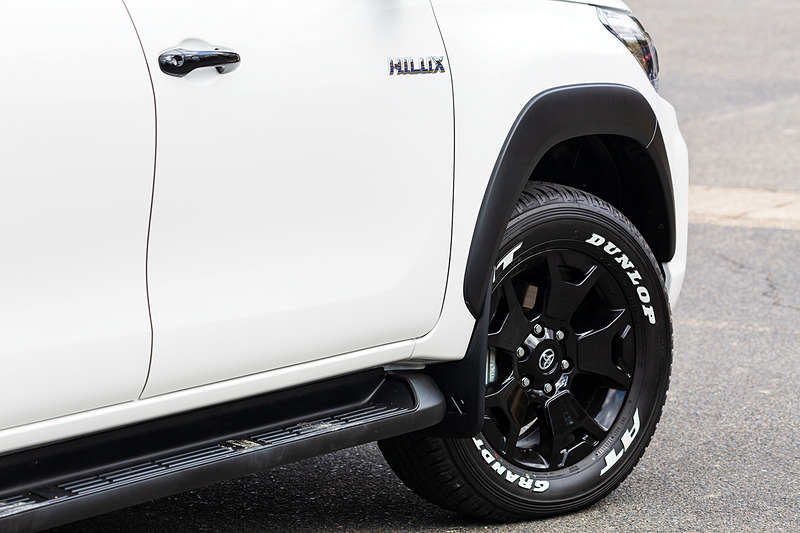 Z“Black Rally Edition”はハイラックスの上級グレード「Z」をベースに、専用デザインのアルミホイールやフロントグリル、バンパーなど採用し、これらをブラック塗装で統一。また、4輪の存在感を強調するブラック塗装のオーバーフェンダーや18インチのホワイトレタータイヤ（265/60 R18）、ブラックメタリック塗装のドアミラー＆アウトサイドドアハンドル、ブラック塗装のテールゲートハンドル、グレー塗装のリアバンパーなどによってベース車との差別化を図っている