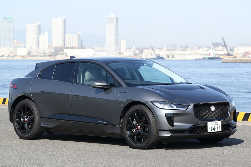 撮影車は「I-PACE HSE」(1162万円)。ボディカラーは「コリスグレイ」。ブラックエクステリアパック、電子制御エアサスペンション、固定式パノラミックルーフ、アダプティブサーフェイスレスポンス(AdSR)などのオプションを装着する。ボディサイズは4695×1895×1565mm(全長×全幅×全高)、ホイールベースは2990mmで、最小回転半径は5.6m。前後にそれぞれ1基ずつ計2基を搭載する「TZ-204」型モーターを90kWhのリチウムイオン電池で駆動し、システム最高出力は294kW(400PS)/4250-5000rpm、最大トルク696Nm/1000-4000rpmを発生。WLTCモード航続距離は438kmとなる