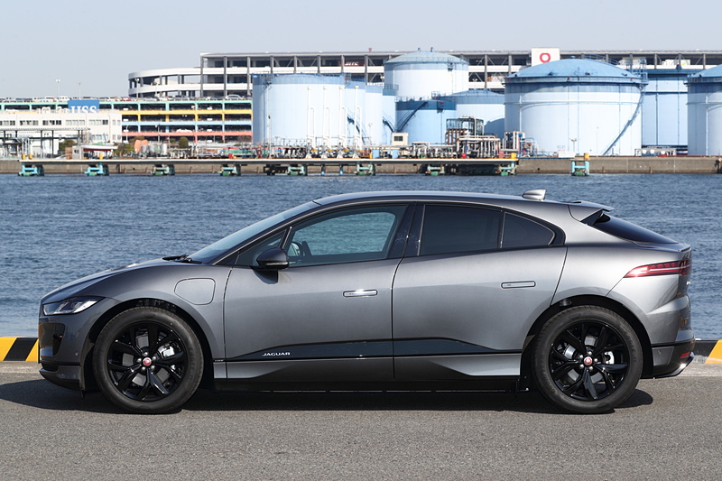 撮影車は「I-PACE HSE」（1162万円）。ボディカラーは「コリスグレイ」。ブラックエクステリアパック、電子制御エアサスペンション、固定式パノラミックルーフ、アダプティブサーフェイスレスポンス（AdSR）などのオプションを装着する。ボディサイズは4695×1895×1565mm（全長×全幅×全高）、ホイールベースは2990mmで、最小回転半径は5.6m。前後にそれぞれ1基ずつ計2基を搭載する「TZ-204」型モーターを90kWhのリチウムイオン電池で駆動し、システム最高出力は294kW（400PS）/4250-5000rpm、最大トルク696Nm/1000-4000rpmを発生。WLTCモード航続距離は438kmとなる