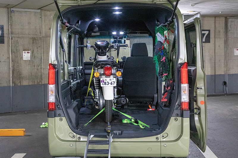 クロスカブ50はレグシールドがないので積むのが楽。車体を右寄りにできるからハンドルが真っすぐで固定できる。クロスカブ110も同様だろう。スーパーカブC125（写真右）は小振りなレグシールドがあるので、積載イメージはCB125Rと同じ感じだと思われる