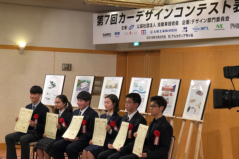 「第7回カーデザインコンテスト」の表彰式にて、ちょっぴり緊張気味!?な6名の受賞者たち。過去最高となった386件の応募作品の中から選ばれた精鋭たちです。写真は、右からカーデザイン大賞の岩片智さん、カーデザイン賞（高校生の部）の林侑太朗さん、ダビンチ賞（高校生の部）の滝川麻友さん、カーデザイン賞（中学生の部）の魚住拓磨さん、ダビンチ賞（中学生の部）の長尾美雨さん、審査員特別賞のキム・ジョンミンさん