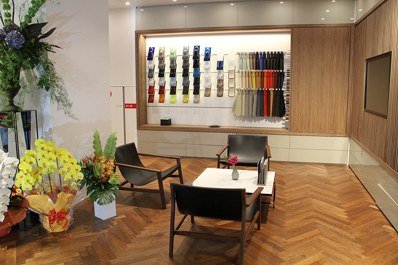 全体的に温かみのあるデザインが特徴的なショールーム内ではカラーや素材のサンプル展示に加え、アパレルグッズなどの販売も行なっている