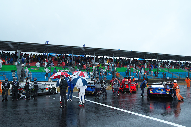 レース中断後、マシンを並べてドライバーやチームスタッフがファンにあいさつ。雨の降りしきる中、特別なイベントを実施した