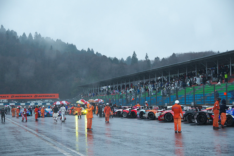 レース中断後、マシンを並べてドライバーやチームスタッフがファンにあいさつ。雨の降りしきる中、特別なイベントを実施した
