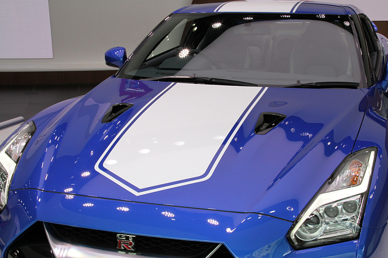 リアまわりに「GT-R 50th Anniversary」の文字をあしらったバッヂとステッカーを装着。ワンガンブルーのモデルでは、ボディカラーとコーディネートして設定した50周年記念ロゴ入りのブルースポークホイールを標準装備。タイヤはダンロップ「SP SPORT MAXX GT600 DSST CTT」（フロント：255/40ZRF20、リア：285/35ZRF20）