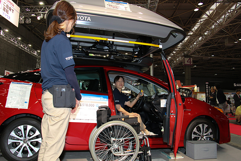 車両解説員による「ウェルキャリー」作動デモも実施。なお、前面投影比の大きなウェルキャリーを設置すると燃費に大きく影響するため、装着はハイブリッドカーであるプリウスと「アクア」に限定しているとのこと