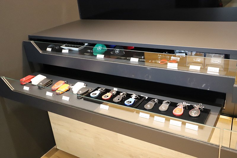ディスプレイ下の壁面にはキーホルダーやミニカーなどのグッズのほか、ボディカラー見本を用意