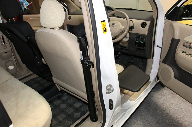 車いすの座面から運転席に移乗する時に利用する「ティップアッププレート（昇降電動モデル）」。Bピラー後方に設置したモーターを使い、車いすと運転席の高さの違いを電動昇降で解消する