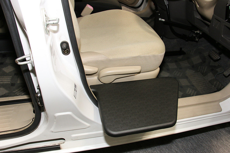 車いすの座面から運転席に移乗する時に利用する「ティップアッププレート（昇降電動モデル）」。Bピラー後方に設置したモーターを使い、車いすと運転席の高さの違いを電動昇降で解消する