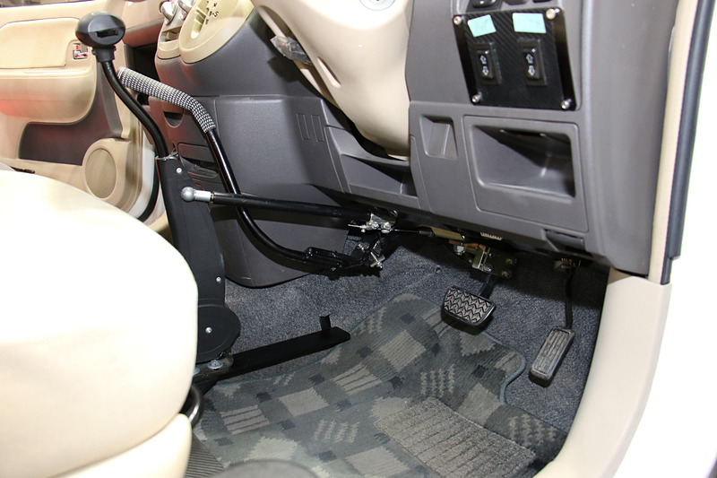 アクセルとブレーキを手動操作する「カロスピードメノックス」。逆側からでもウインカーを操作できる「ウインカー変換レバー」も装着している