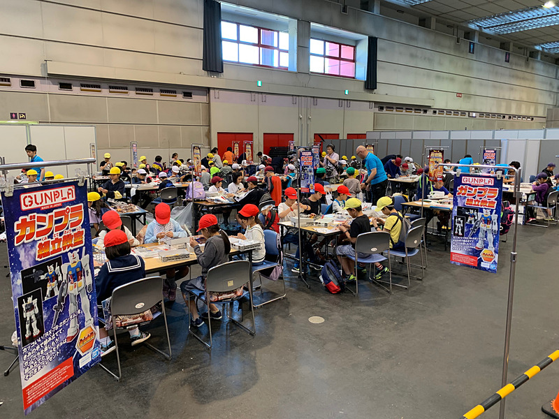 帽子をかぶった小学生が体験コーナーで模型製作を行なったり、展示物の見学をしていた