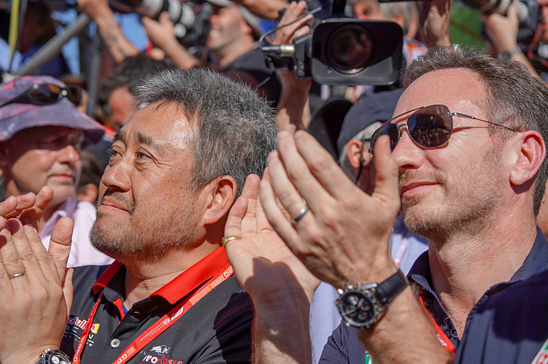 表彰台の下で、マックス・フェルスタッペン選手の表彰を祝福するホンダ F1 マネージングディレクター 山本雅史氏（左）とレッドブル・レーシング チーム代表 クリスチャン・ホーナー氏（右）