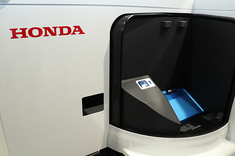 人感センサーによってリッドを開閉。使用済みのモバイルパワーパックをトレーに置くと充電済みのモバイルパワーパックと差し替えられる。充電の待ち時間がなくなるほか、バッテリーの状態をホンダが把握して、ユーザーが常にコンディション良好なモバイルパワーパックを利用できるようコントロールしている