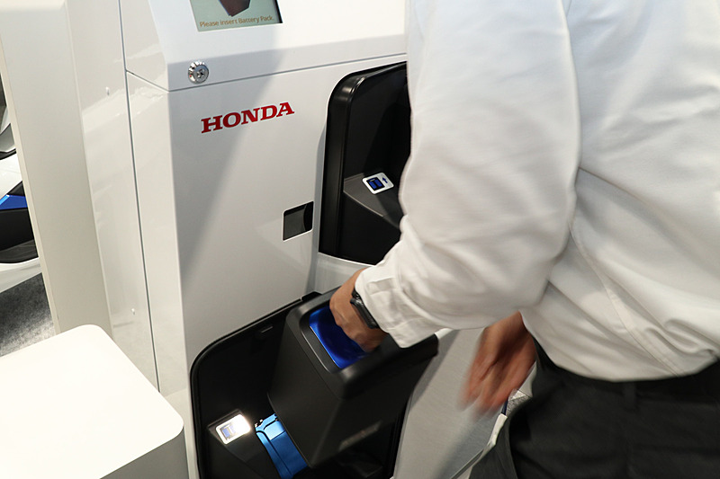 人感センサーによってリッドを開閉。使用済みのモバイルパワーパックをトレーに置くと充電済みのモバイルパワーパックと差し替えられる。充電の待ち時間がなくなるほか、バッテリーの状態をホンダが把握して、ユーザーが常にコンディション良好なモバイルパワーパックを利用できるようコントロールしている