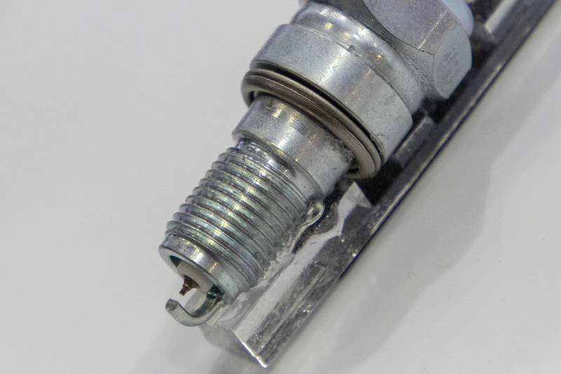 こちらは東京モーターサイクルショーで発表されたオートバイ専用のスパークプラグ。外側電極の断面をD形状にすることで、火炎がきれいに燃え広がるようになっている。社内テストでは30-80km/hの到達時間を従来プラグ装着車より0.2秒短縮。80km/hでこのタイム差は距離にすると約4mなので、見過ごせないほどの効果だ