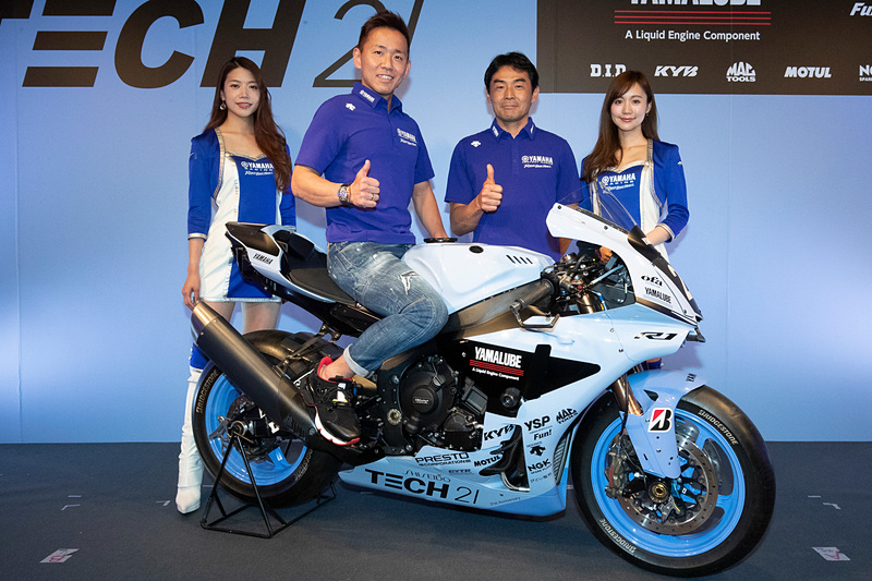 「ヤマハTECH21チーム」復刻カラーを採用した参戦マシンと「#21 YAMAHA FACTORY RACING TEAM」の中須賀克行選手（左から2番目）、吉川和多留監督（左から3番目）