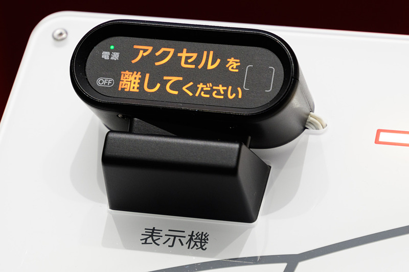 デンソーは、後付け可能な「ペダル踏み間違い加速抑制装置」を展示。これは社内に取り付ける表示機