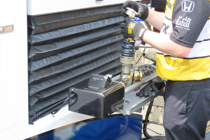 リアサスペンションのスプリングを交換するメカニック