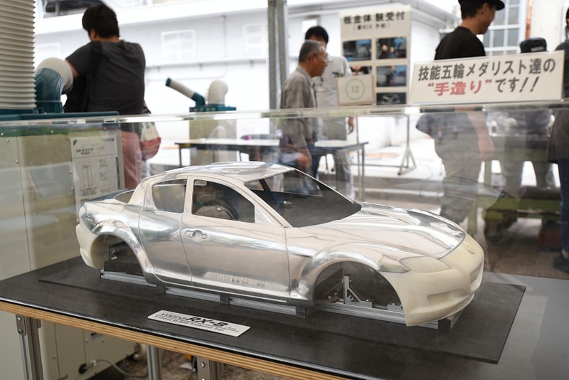 マツダのモノ造りを紹介するコーナーでは、塗装や板金、パワートレーンなどあらゆる技術を解説。ソウルレッドに塗られた「RX-7（FD3S）」のバンパーも展示されていた