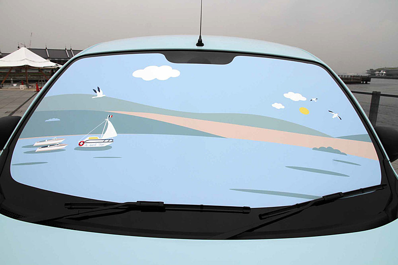 フロントウィンドウとリアハッチは、船が浮かびカモメが飛ぶサントロペの港の風景