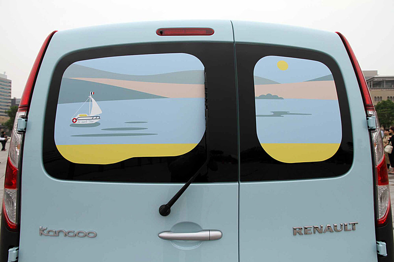 フロントウィンドウとリアハッチは、船が浮かびカモメが飛ぶサントロペの港の風景