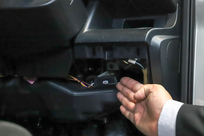 実際に試乗をする前に、ペダルの見張り番を装着した日産自動車「セレナ」に乗って、駐車している状態でアクセルを踏み込んでいた小池都知事。セレナではステアリング右側にペダルの見張り番が装着されていた