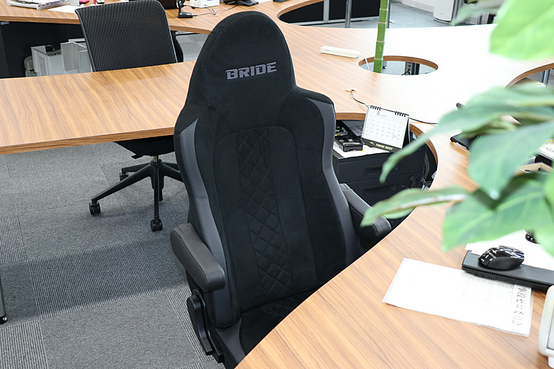 事務所スペースには観葉植物が置かれ、ブリッド製のスポーツシートを流用するオフィスチェアを採用