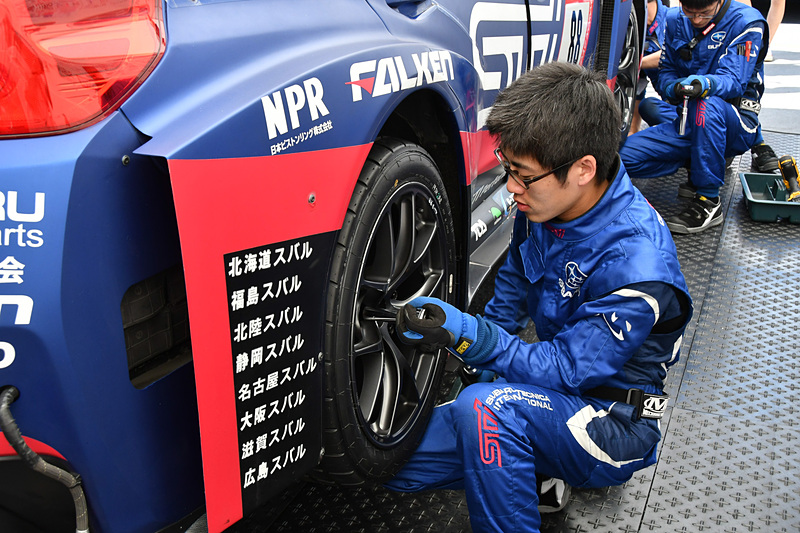 タイヤ交換などチェック。SUBARU WRX STIには、車両後部にディーラーメカニックが所属する販売会社名が書かれていた