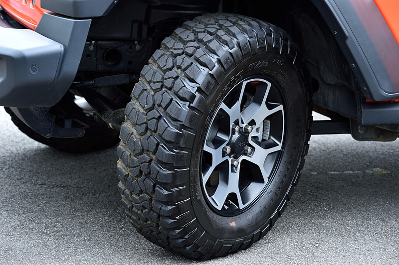 試乗車のアンリミテッド・ルビコンではルビコン専用の17インチアルミホイールにBFGoodrichブランドのオフロード用4×4ラジアルタイヤ「Mud-Terrain T/A KM2」（LT255/75R17）を装着。エクステリアでは標準仕様のサイドステップを車体のダメージを緩和するロックレールへと変更したほか、ダークグレーのアクセント入りフロントグリルや、ブラック仕様のハードトップおよびフェンダーフレア、フロントフェンダーのRubiconデカールなどが特徴になっている