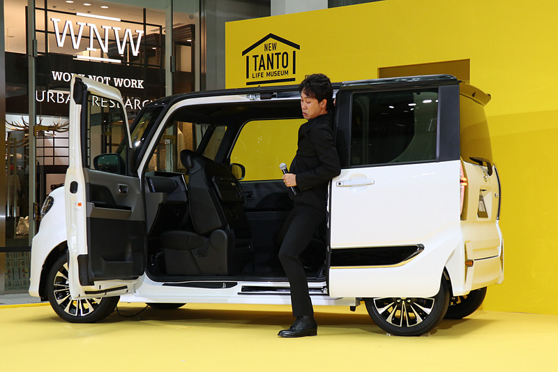 まずは大泉さんがタント カスタムの「ミラクルオープンドア」を開け、独自の広々とした開口部について紹介。タントでは広い開口部でスムーズに乗り降りできることを実演し、「ほかのクルマなんてねぇ、こんなもんですよ」（写真右下）と、かなり大げさなアクションも交えてミラクルオープンドアの魅力を説明した