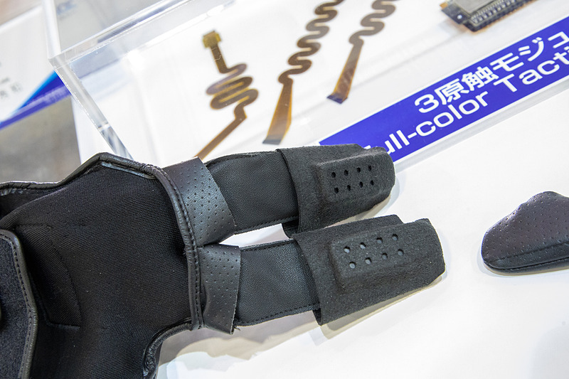 会場では「3原触モジュール」が体験できる。取材班も試させていただいたが、スタッフが装着したグローブが受けた触感や振動、温度がよく分かるものだった。例えば建築など伝統的なもの作りの技術伝授など、名人技の感覚をデータ化して後世に伝えるなど文化的な使用法もあるだろう