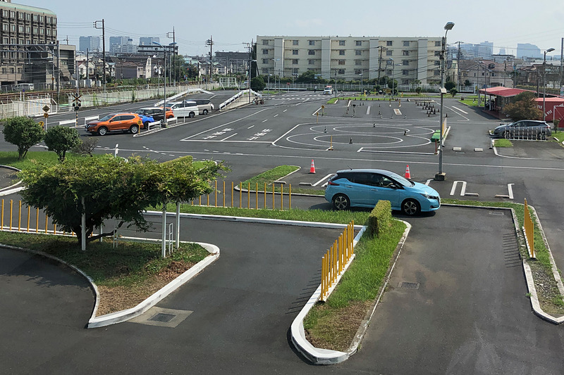 日産自動車の企画「コソ練試乗会」が開催されたのは、東京都大田区にある「ラヴィドライビングスクール蒲田」という自動車教習所。外周路の内側に坂道や踏切、クランクなどの規定コースがあって、いや～、懐かしい光景です（笑）。普段の教習車には、ハローキティがラッピングされた日産「ティーダ」が並んでいました