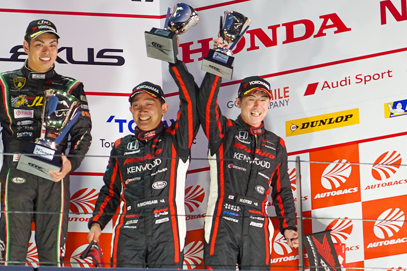 表彰台でトロフィを掲げる道上龍選手（中央）と大津弘樹選手（右）