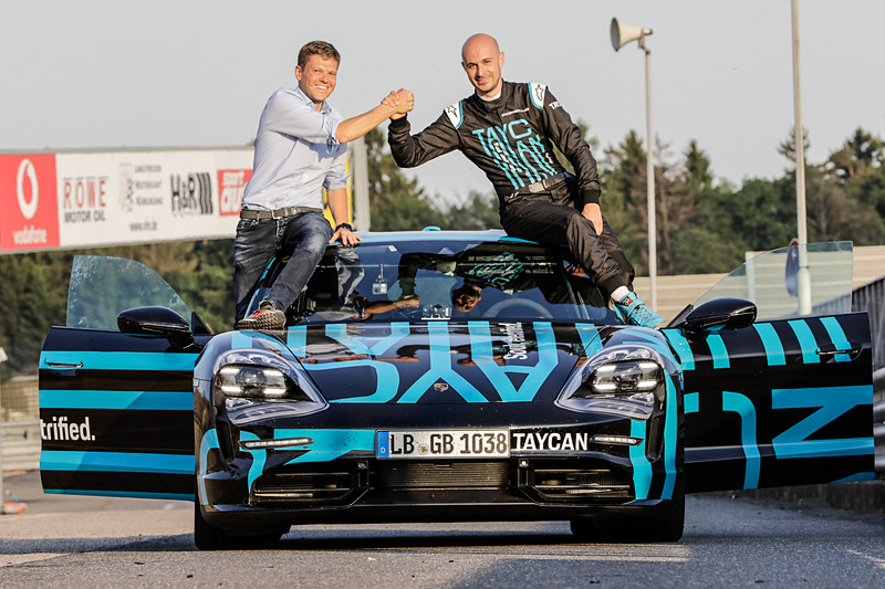 ラップタイム計測を実施したスポーツEV「タイカン」プロトタイプの上で笑顔を見せるタイカン プロダクト責任者のシュテファン・ヴェックバッハ氏（左）とテストドライバーのラース・ケルン氏（右）