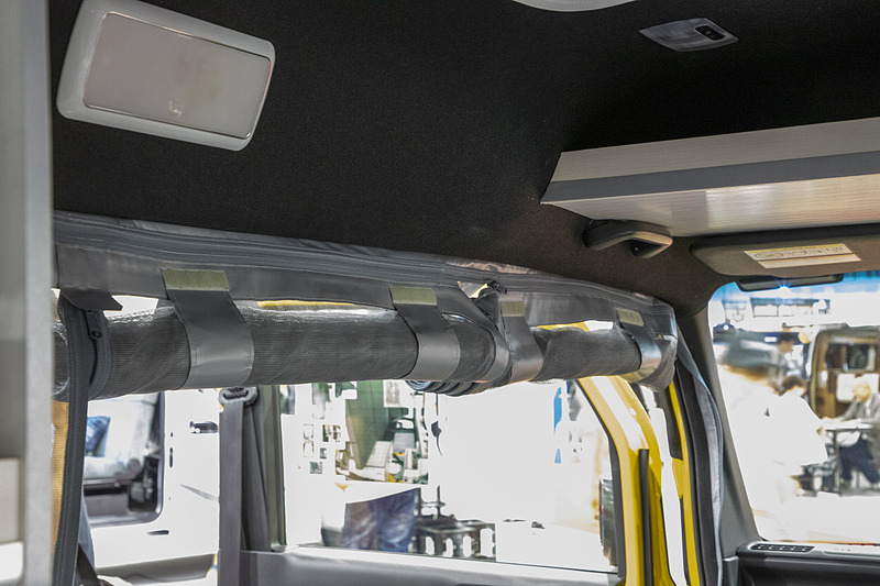 内装にはめ込んで固定してファスナーで開閉する防虫ネット。不要なときはロールアップしておける。車中泊やオートキャンプをしている人向き。リアゲート用とセットで7万2000円（税別）で販売している