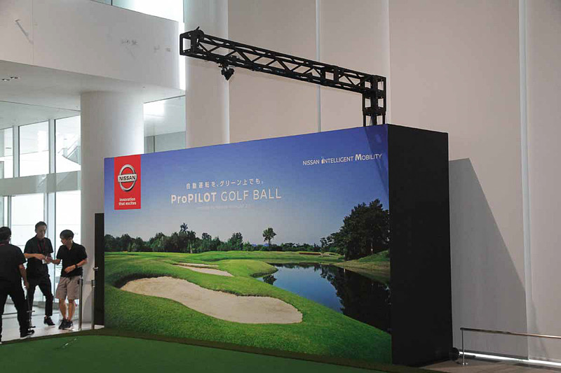 日産グローバル本社ギャラリーに特設された体験グリーン。グリーン上に設置した3つのカメラでグリーン全体の情報をピップアップし、コンピューターで解析。カップまでの移動に必要な動きをゴルフボールにワイヤレスで指示する仕組み