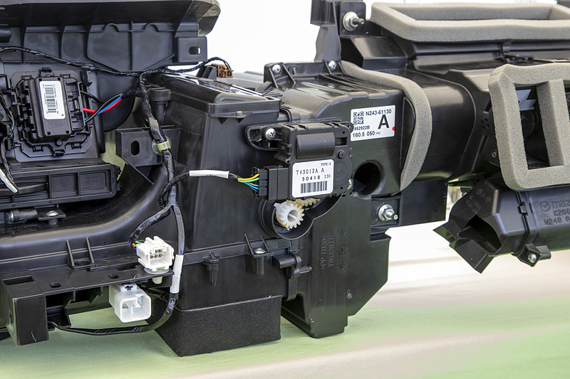 マツダ「ロードスター」に採用されているセミセンター式空調ユニット。省スペースながら効率よく空気を取り込める。また、内部の空気通路は複雑な形状ながら圧力損失が少ないよう設計され、なおかつどの吹き出し口からも均等な量、同じ温度の風を出せるようにしている。空気を流すことについてはボディの空力以上に凝った内容とも言える部位だ