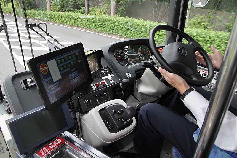 運転士はステアリングに軽く手を添えているだけで、車両が自動的にステアリング操作やアクセルワークなどを行なってくれる。緊急時にステアリングなどを操作すると自動運転が解除され、運転士が操作を引き継ぐ