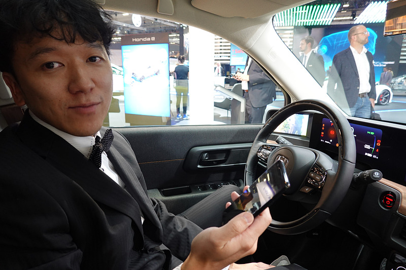スマートフォン片手に運転席に座る安藝氏