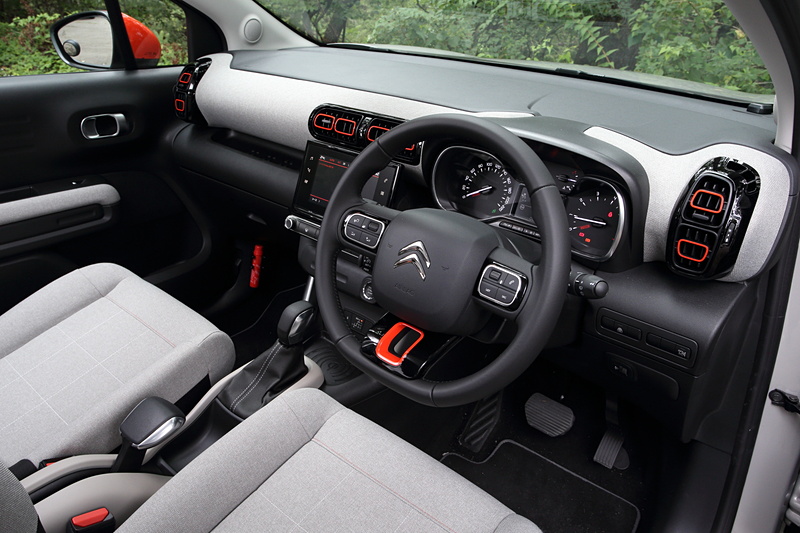 C3 エアクロス SUV SHINEのインテリア。グレーのシートやオレンジの差し色がポップな印象を与えている。また、インパネにもシートと同じ生地が用いられ、室内に暖かみを加えている