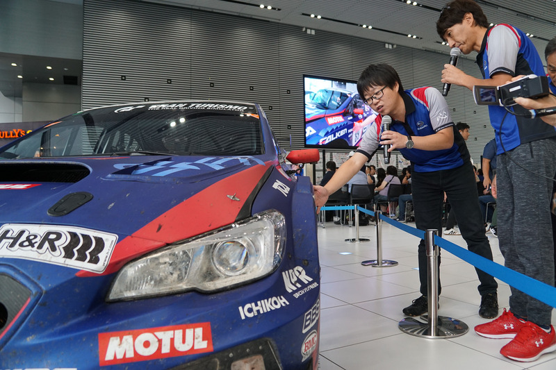 他のマシンと接触するトラブルが発生したときの気持ちなどを実車を前に説明する、STI 車両実験部 チーフエンジニアの宮沢竜太氏