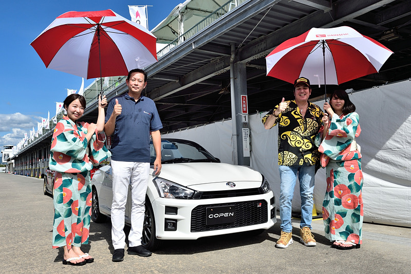 コペン GR SPORT コンセプトと一緒にレーサー気分で撮影する坪内孝暁社長とジェイムス・ヘイブンスさん