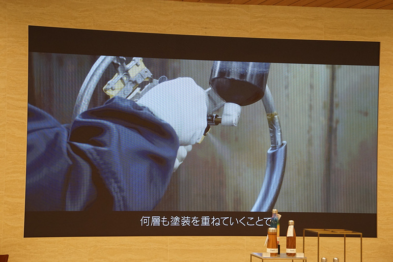 本杢の表面は職人の手作業による研磨で本革と変わらない滑らかな質感に磨き上げ、藍塗装では塗膜を可能な限り薄くすることで極薄のアルミ層がベースのブラック層を効果的に透過。塗装はすべての工程を専門職人の手吹きで行い、自然素材が持つ本物の質感を表現した