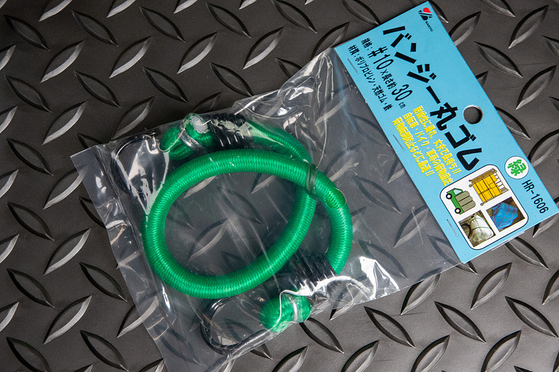 写真のような大きめのフック付きゴムバンドを使うので、純正アクセサリーのDリングタイプではリングの部分が小さかった