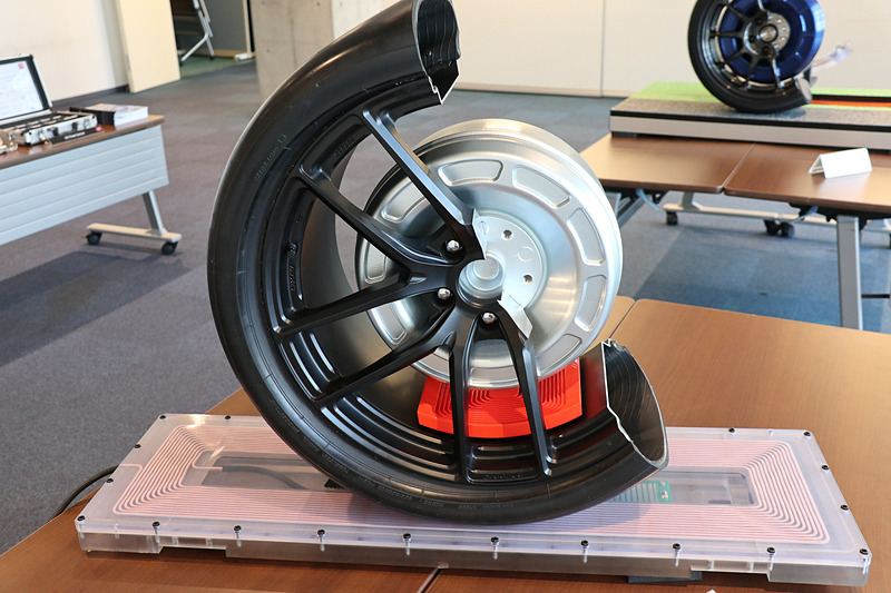 タイヤは非金属のベルトを採用。ホイールも炭素繊維素材を使ったものを採用してオレンジ色にしてある受電コイルにロスなく電気が届くようになっている