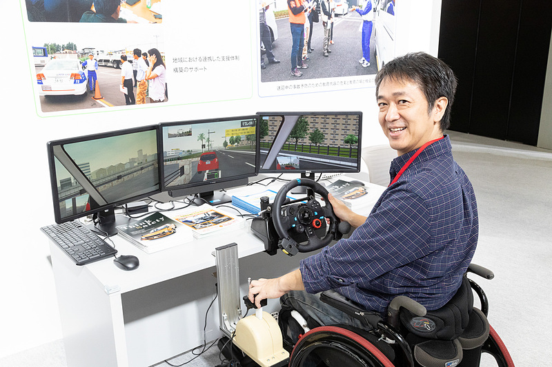 3画面のモニターと専用PC、運転評価ソフト、（手動）運転装置からなる、簡易型4輪ドライビングシミュレーターの「Honda セーフティナビ」