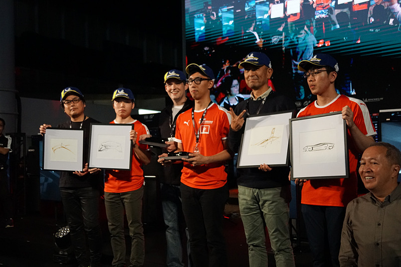 「ジャガービジョン グランツーリスモ Coupe」を使用したレース「ワールドツアー・エキシビション・プロアマレース」の表彰台。優勝GT Planet/K.L.Li（中央のペア）、2位Car Watch/T.Miyazono（左端のペア）、3位Autosport/R.Kokubun（右端のペア）