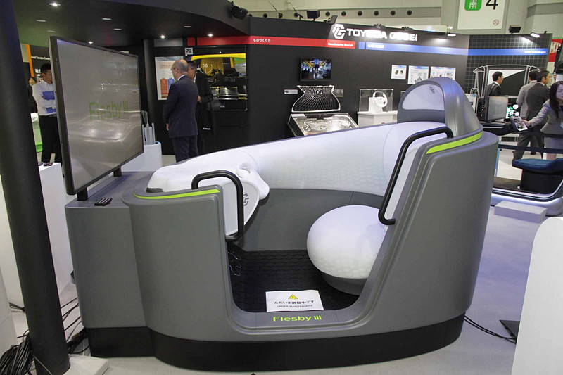 2030年ごろのコンパクトモビリティを想定したエクステリア＆インテリアの将来コンセプトモデル「Flesby III」。ゴム・樹脂技術を活用した柔らかなボディと、AI（人工知能）を組み合わせることで、スキンシップによりコミュニケーションができる相棒のようなクルマとした。万が一、歩行者と接触した場合でも衝撃を吸収するという柔らかな車体が特徴。走行シーンに合わせて車体の形状を最適に変化させ、空気抵抗を減らせることができる。インテリアは柔らかな素材にやさしく包み込まれる安心感と、シーンに応じて色合いが変わるLED照明などで、リラックスできる快適な移動空間を提供するファーストクラス機能を備えている